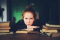 Indoor portrait of beautiful redhead woman learning or reading books in university Royalty Free Stock Photo