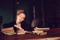 Indoor portrait of beautiful redhead woman learning or reading books in university Royalty Free Stock Photo