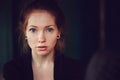 Indoor portrait of beautiful redhead woman learning or reading books in university Royalty Free Stock Photo