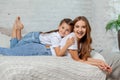 Indoor portrait of a beautiful mother with her charming little daughter posing against bedroom interior. Royalty Free Stock Photo