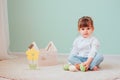 Indoor portrait of cute happy baby girl playing with easter decorations Royalty Free Stock Photo