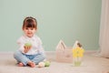 Indoor portrait of cute happy baby girl playing with easter decorations Royalty Free Stock Photo