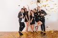 Indoor portrait of glad students having fun at home disco and drinking champagne. Happy friends in stylish attires Royalty Free Stock Photo