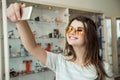 Indoor portrait of good-looking young woman in optician store, buying new pair of sunglasses to protect eyes from sun Royalty Free Stock Photo