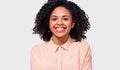 Indoor portrait of happy African American young woman, dressed in casual beige shirt, smiles pleasantly at camera Royalty Free Stock Photo