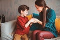 indoor portrait of happy mother and child son sitting on couch and playing Royalty Free Stock Photo