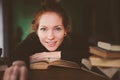 indoor portrait of redhead happy student woman learning or reading books Royalty Free Stock Photo