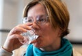 Indoor portrait of a 35 year old woman drinking a glass of water Royalty Free Stock Photo