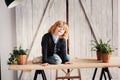 Indoor portrait of 5 years old boy with long hair sitting on table Royalty Free Stock Photo