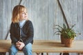 Indoor portrait of 5 years old boy with long hair sitting on table Royalty Free Stock Photo