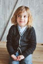 Indoor portrait of 5 years old boy with long hair sitting on table Royalty Free Stock Photo
