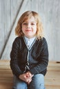 Indoor portrait of 5 years old boy with long hair sitting on table Royalty Free Stock Photo