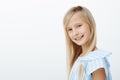 Indoor profile portrait of charming caucasian fair-haired young girl in trendy blue blouse, smiling broadly and feeling Royalty Free Stock Photo