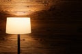 Indoor scene of a floor lamp against wooden wall Royalty Free Stock Photo