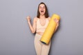 Indoor shot of amazed extremely happy joyful athletic woman clenched fist celebrating her achievment in gym, yelling with