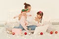 Indoor shot of beautiful woman with hair bun and her two children using laptop computer for talking via video call while sitting Royalty Free Stock Photo