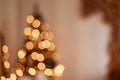 Indoor shot of blurred Christmas tree with yellow garland lights in festive room. Merry Christmas and Happy new year Royalty Free Stock Photo
