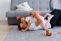 Indoor shot of cute female child hugging happy dad lying on floor while spending time together, family with hairpins expressing Royalty Free Stock Photo