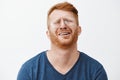 Indoor shot of gloomy and upset redhead mature man with beard, tilting head behind, frowning and grimacing, complaining Royalty Free Stock Photo