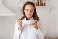 Indoor shot of happy hungry young adult woman with dark hair eating from plate in the morning, smelling soup or other food, posing Royalty Free Stock Photo