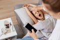 Indoor shot of mother calls a doctor because of her daughter having illness, sleepy little girl yawning and feeling bad, suffering Royalty Free Stock Photo