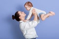 Indoor shot of mother playing with baby boy, happy family having fun at home, cheerful sweet kid in mom`s arms, mom and child Royalty Free Stock Photo