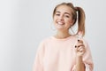 Indoor shot of pretty positive teenage girl with two ponytails, dark appealing eyes and healthy pure skin, smiling