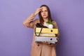 Indoor shot of sad sick unhealthy Caucasian woman wearing official style jacket holding folders isolated over purple background,