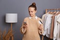 Indoor shot of serious concentrated woman holding cell phone and credit card and entering bank data while paying for her purchases Royalty Free Stock Photo