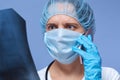 Indoor shot of shocked female doctor examining patient`s x-ray, talking via phone with her colleague, portrait of beautiful young Royalty Free Stock Photo