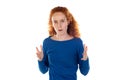 Indoor shot of stressed and annoyed young redhead Caucasian woman with curly hair holding hands in mad furious gesture, screaming