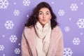 Indoor shot of stylish lady wearing pale pink oversize eco fur coat blowing kiss. Portrait of wavy haired woman posing over