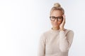 Indoor shot of successful cheeky and stylish european blond female with combed haircut in glasses smirking arrogant and