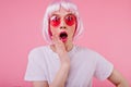 Indoor shot of surprised female model in short periwig and bright sunglasses. Portrait of shocked y