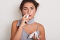 Indoor shot of young unhealthy woman with runny nose, holding handkerchief in hand, lady caught cold, suffering from flu or Royalty Free Stock Photo