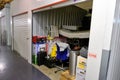 Indoor storage unit with open door and household goods in a self storage facility. Rental Storage Units. Netherlands Royalty Free Stock Photo