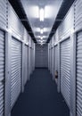 Looking down hallway with metal storage unit doors on each side. Royalty Free Stock Photo