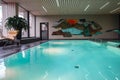 Modern indoor swimming pool oasis with serene turquoise waters and abstract wall art Royalty Free Stock Photo