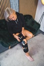 Indoor vertical photo of a woman with bandage orthosis compression knee brace support injury