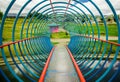 Indoor view of the colorful bridge over an artificial lake located in the midle of a park with the reflection in the Royalty Free Stock Photo