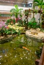 Indoor view of people walking in a small garden with plants inside of Singapore Changi Airport. Singapore Changi Airport