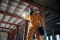 Indoors with flashlight. Man dressed in chemical protection suit in the ruins of the post apocalyptic building