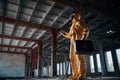 Indoors with flashlight. Man dressed in chemical protection suit in the ruins of the post apocalyptic building