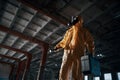 Indoors with flashlight. Man dressed in chemical protection suit in the ruins of the post apocalyptic building