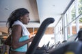 Indoors gym portrait of young attractive and beautiful black afro American sporty woman training treadmill running workout at fitn Royalty Free Stock Photo