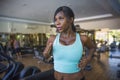 Indoors gym portrait of young attractive black afro American woman training hard all sweaty at fitness club a treadmill running wo Royalty Free Stock Photo