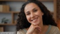 Indoors portrait extreme close up female face with perfect skin make-up pensive dreaming thoughtful Hispanic 30s woman