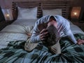 Indoors portrait of young desperate and depressed man at home bedroom sitting on bed sad and confused suffering pain and depressio Royalty Free Stock Photo