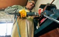 Indoors shot of worker adult man manufacturing in his workshop. Confident craftsman grinding with sparks in repair shop