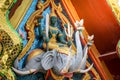 Indra statue carries two elephants holding a weapon using a trumpet holding a lotus on a temple roof.